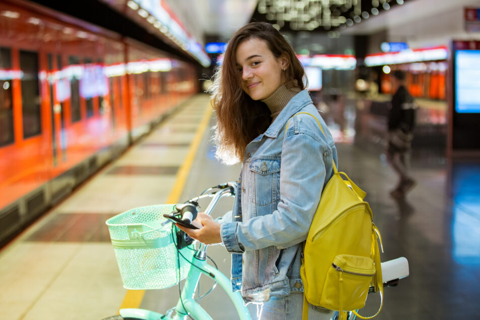 Nuori nainen taluttaa polkupyörää Helsingin metron metrolaiturilla.